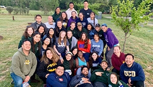 Group of college students packed together for image in field