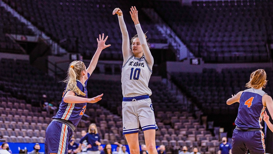 Lena Svanholm shooting a basketball towards the hoop with opposing team member playing defense