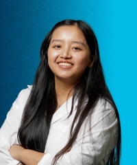 Jennifer Dang in front of a blue backdrop.