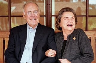 Gordon and Betty Irene Moore seated on a bench laughing. Betty has one hand around Gordon's arm.